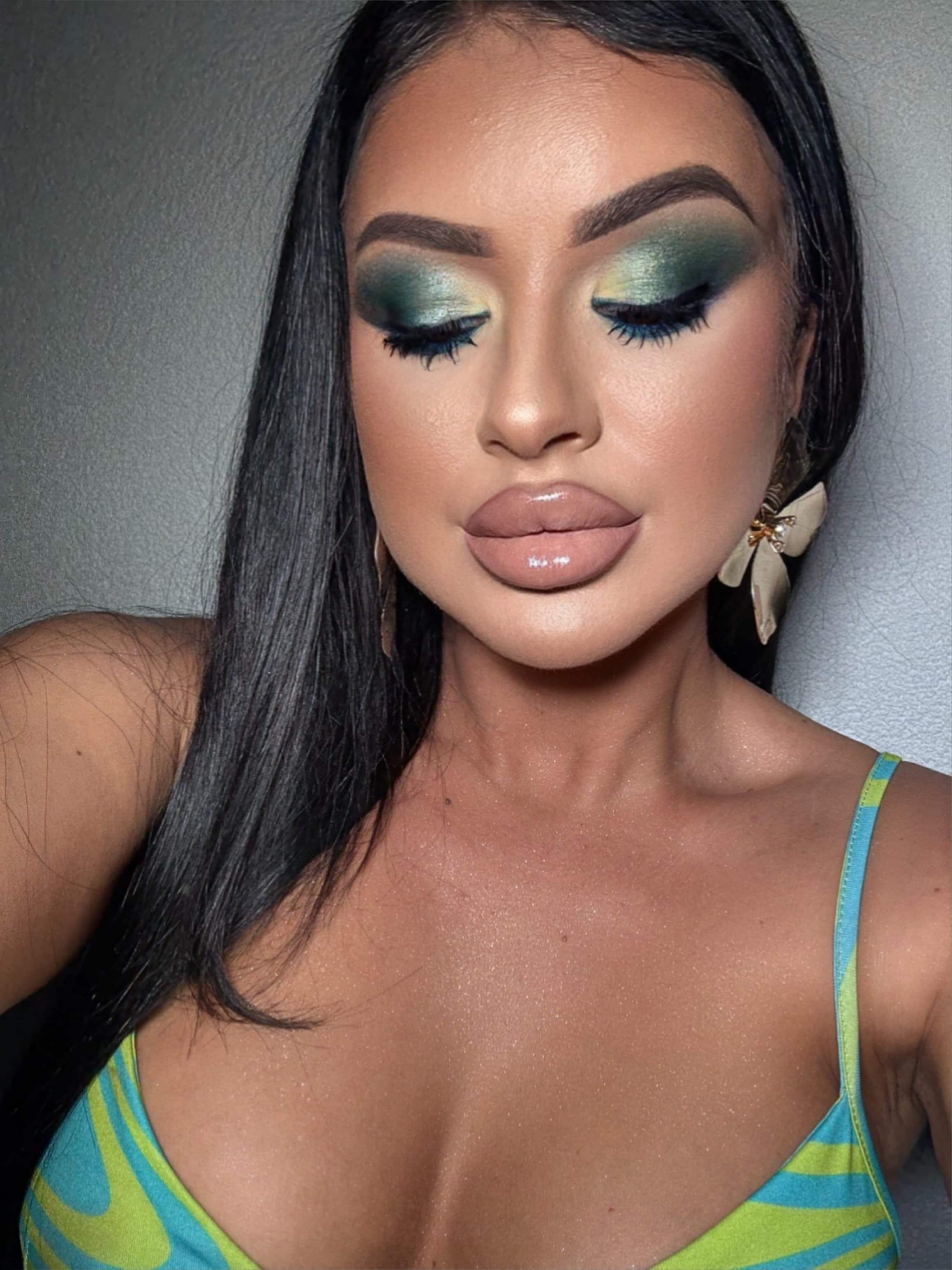 Fard verde smarald cu reflexe aurii și linie albastră sub ochi, buze nude lucioase. Un look colorat și îndrăzneț.